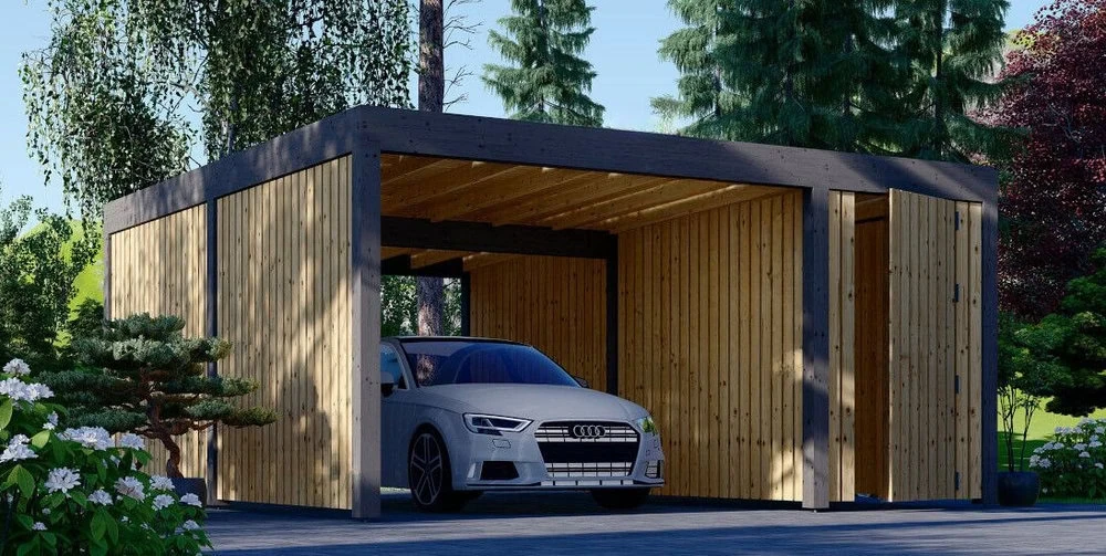 Nowoczesny drewniany garaż Ringo mieści srebrny samochód, otoczony bujną zielenią drzew i zielenią. Wiata ma otwartą konstrukcję z pionowymi panelami drewnianymi i płaskim dachem, wtapiając się w naturalne otoczenie.