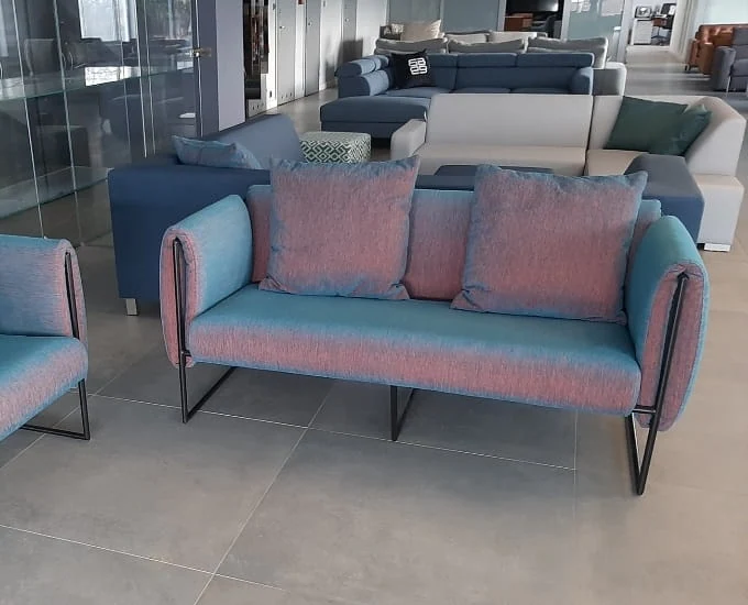Holograficzna sofa dwuosobowa „Goa” w kolorze niebiesko-różowym na czarnej metalowej ramie z dwiema poduszkami oparcia.