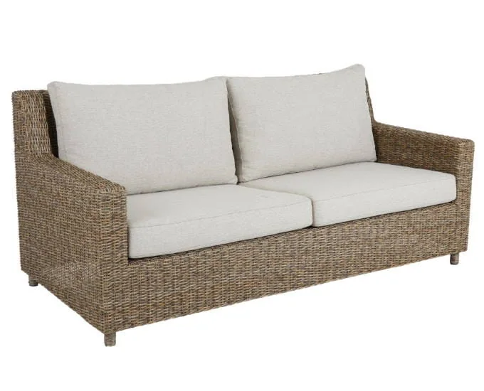 Dwuosobowa sofa wiklinowa Sandkorn z jasnymi poduszkami na siedzisko i oparcie.