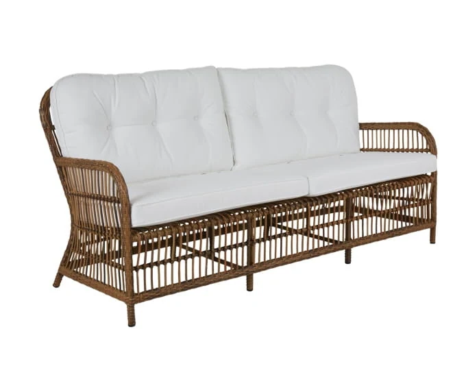 Sofa „Anemon” w stylu retro z wiklinowym stelażem i dwuczęściowymi białymi pikowanymi poduszkami.