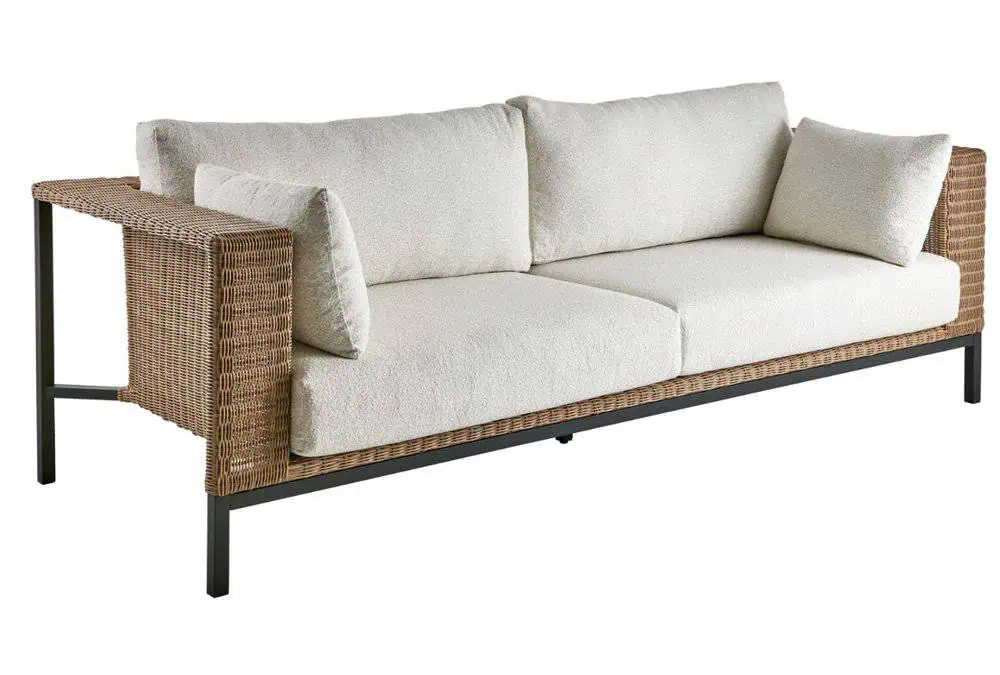 Sofa ogrodowa Shell z plecionymi bokami, czarną metalową ramą i kremowymi poduszkami.