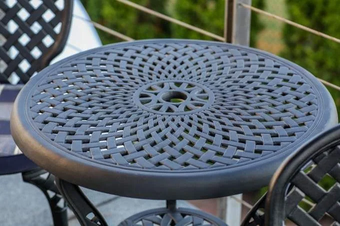 Okrągły metalowy stolik „Manhattan” z plecionym wzorem i otworem na parasol.